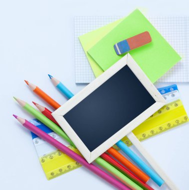 Okul Conceptl başa: renkli Pancils, yaprak kağıt, küçük yazı tahtası beyaz arka plan üzerinde