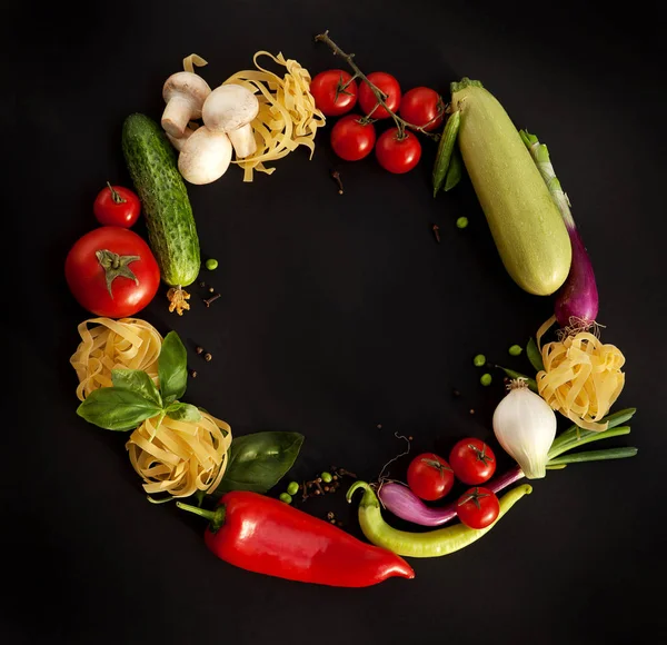 Wreath of Fine Food Products - Fresh Vegetables, Homemade Pasta and Spices on the Black Background