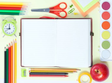 Okul Conceptl başa: boş defter, renkli kalem, kurşun kalem, kalem, kırmızı elma, Sissors, sarı zemin üzerinde boya paleti hissettim