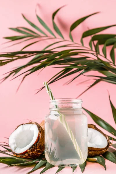 Coconut water and coconuts on a bright pastel background, selective focus.