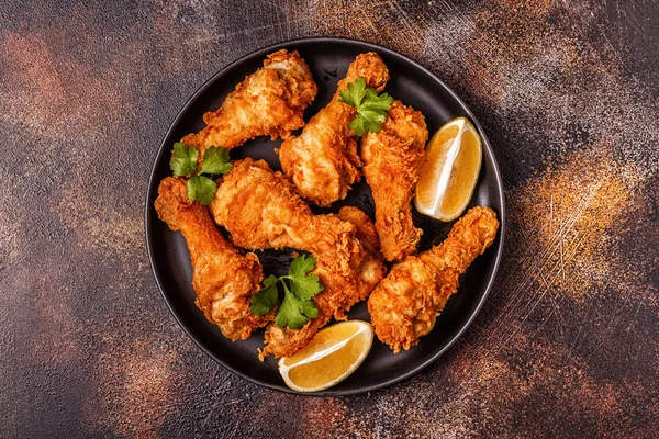 Fried chicken legs with lemon and parsley. Top view