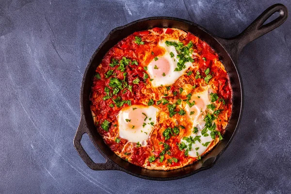 Shakshuka in a Frying Pan. Eggs Poached in Spicy Tomato Pepper Sauce.