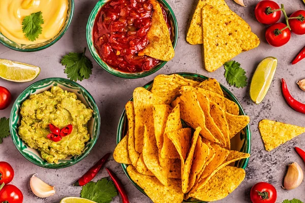 Mexican food background: guacamole, salsa, cheesy sauces with na