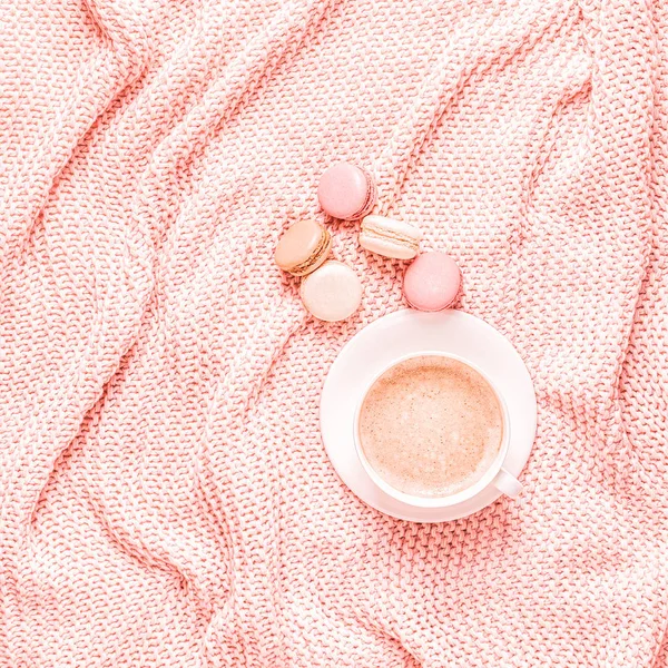 Background with pink plaid, coffee and macaroons.