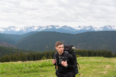 Yürüyüşçü ekipmanlarıyla dağlarda yürüyüş yapar.