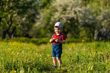 Küçük çocuk çimen renkli oyuncakla oynuyor.