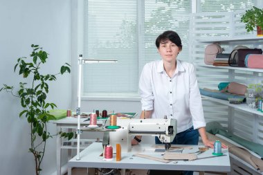 Terzi kız dikiş makinesinin arkasındaki iş yerinde.