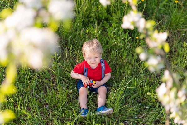 Kleiner Junge Spielt Auf Grasfarbenem Spielzeug — Stockfoto