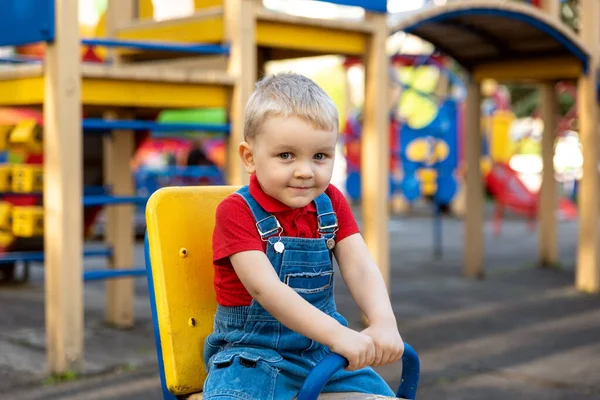 Junge Schaukelt Auf Einem Karussell Auf Einem Spielplatz Auf Der — Stockfoto