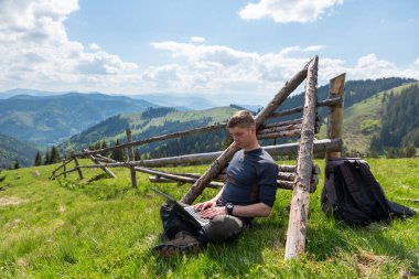Doğada dizüstü bilgisayarda çalışan adam.