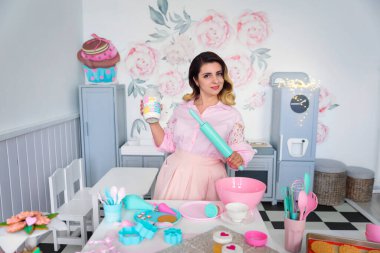 Ellerinde merdane ve kavanoz tutan pasta şefi kız.