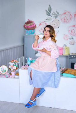 Eski tarz bir kız mutfakta çay içiyor.