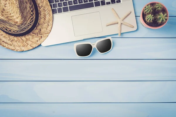 Laptop Okulary Przeciwsłoneczne Słomy Kapelusz Niebieskim Drewnianym Stole — Zdjęcie stockowe