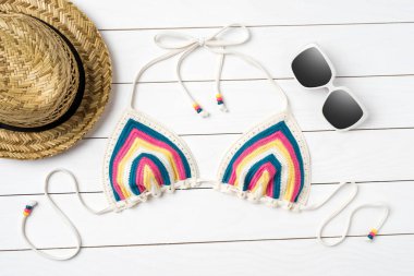 Beyaz ahşap zemin üzerinde plaj aksesuarları ile mayo