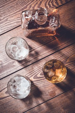 Viski şişesi ve viski bardağı buz küpleri ile. Üstten görünüm