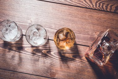 Viski şişesi ve viski bardağı buz küpleri ile. Üstten görünüm