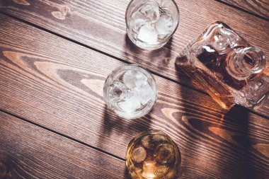 Viski şişesi ve viski bardağı buz küpleri ile. Üstten görünüm