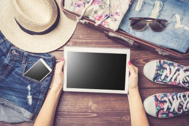 Hazırlıklar gündelik yaz kıyafetleri ile ahşap masa üzerinde seyahat. Üstten görünüm