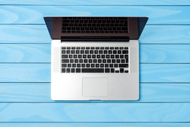 Mavi ahşap masa üstünde modern laptop. Yakın çekim