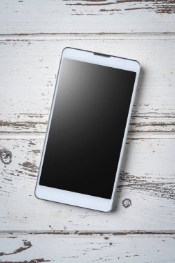Beyaz ahşap zemin üzerinde smartphone. Yakın çekim