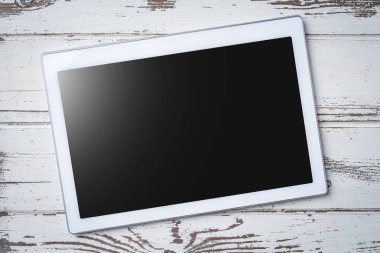 Beyaz ahşap zemin üzerinde dijital tablet. Yakın çekim