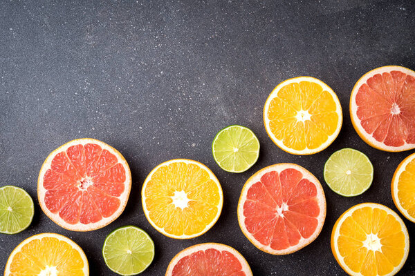 Половина цитрусовых на фоне темного камня
