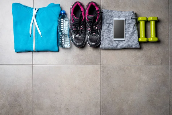 Sport clothing and accessories on gray stone floor