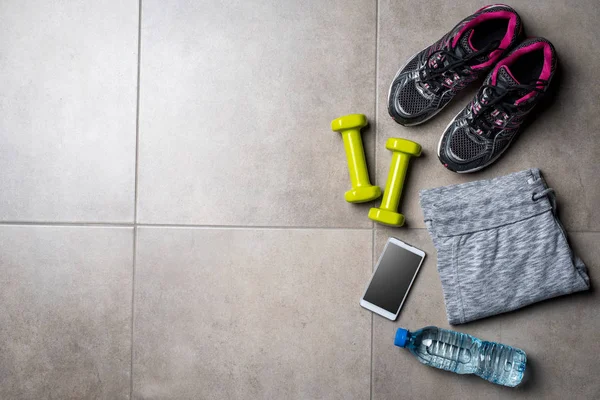 Sport clothing and accessories on gray stone floor