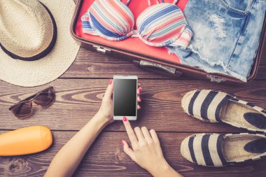 Yaz ya da plaj giysi ve aksesuar ahşap masa üzerinde açık bavul