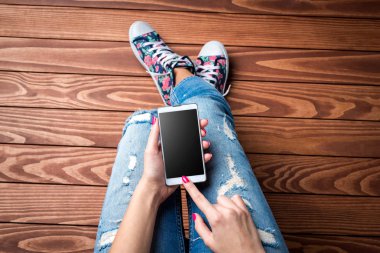 Akıllı telefon kullanan genç bir kadın.