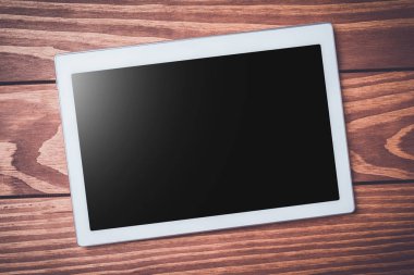 Beyaz ahşap zemin üzerinde dijital tablet. Yakın çekim