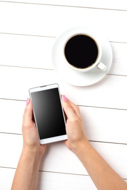 Beyaz ahşap masa üzerinde modern akıllı telefon kullanan kadın