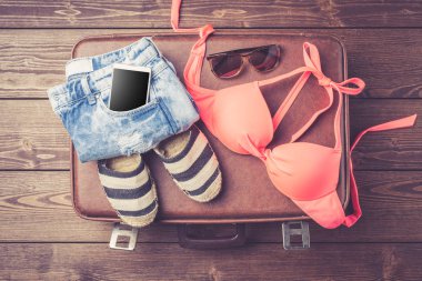 Bavul yazlık giysiler ve aksesuarlar ile. Üstten görünüm