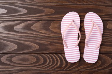 Ahşap arka plan üzerinde genel gider atış pembe Flip floplar