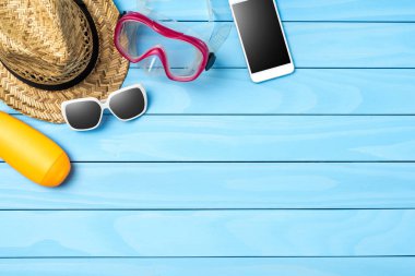 Mavi ahşap arka plan üzerinde plaj veya yaz aksesuarları. Üstten görünüm