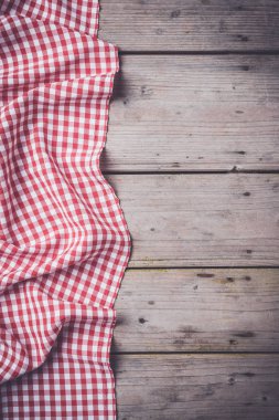 Eski ahşap masa üzerinde kırmızı kareli masa örtüsü. Üstten görünüm