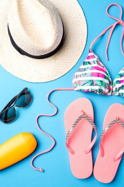 Kadının plaj aksesuarları mavi zemin üzerine