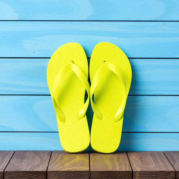 Ahşap zemin üzerine yeşil flip floplar. Yakın çekim