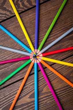 Eski bir ahşap masa üzerinde renkli kalemler