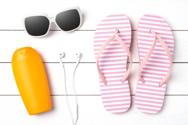 Beyaz ahşap zemin üzerine yaz aksesuarları ile pembe flip flop