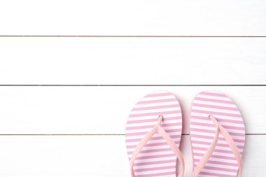 Beyaz ahşap zemin üzerinde pembe flip flop