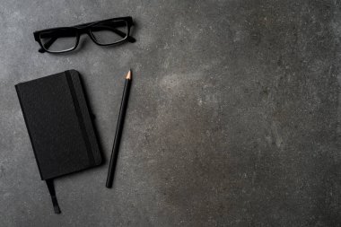 Office Masaüstü kalem, defter ve gözlük ile. Üstten görünüm