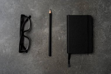 Office Masaüstü kalem, defter ve gözlük ile. Üstten görünüm