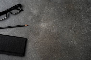 Office Masaüstü kalem, defter ve gözlük ile. Üstten görünüm