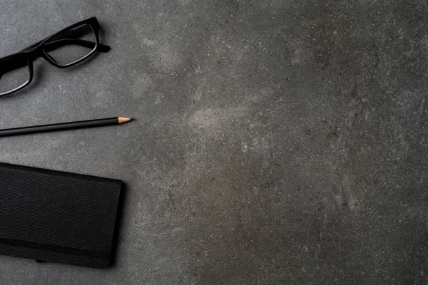 Office Masaüstü kalem, defter ve gözlük ile. Üstten görünüm