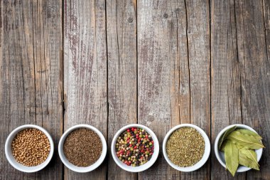 Otlar ve baharatlar eski bir ahşap masa üzerinde beyaz kase