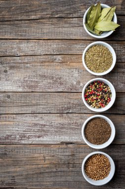 Otlar ve baharatlar eski bir ahşap masa üzerinde beyaz kase
