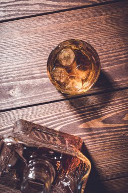 Eski bir ahşap masa camına viski viski şişesiyle