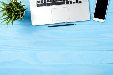 Office masaüstü mavi ahşap arka plan üzerinde modern dizüstü bilgisayar ile