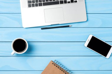 Office masaüstü mavi ahşap arka plan üzerinde modern dizüstü bilgisayar ile